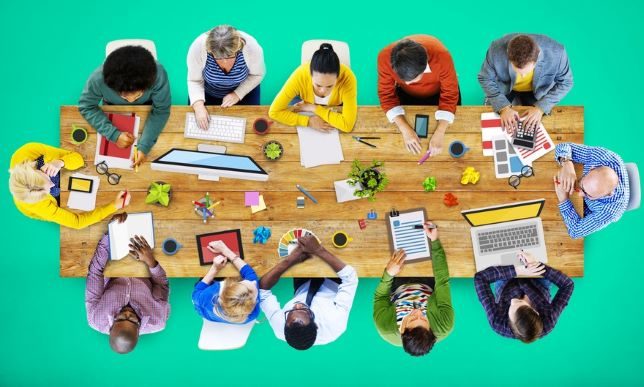 Menschen verschiedener Kulturen sitzen am Tisch